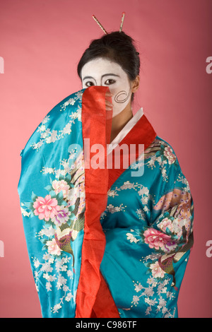 Asiatische Frau mit Geisha-Stil-Bemalung im Yukata (Kimono) Stockfoto