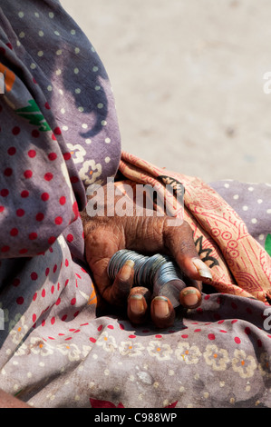 Alte indische Frau betteln mit Rupie-Münzen in der Hand. Andhra Pradesh, Indien Stockfoto