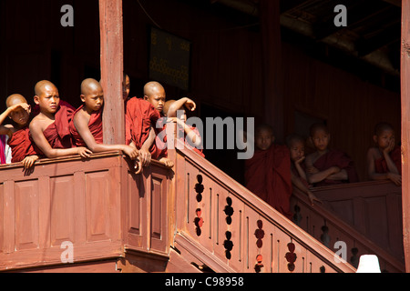 INLE-See, MYANMAR: Junge Mönche vom Kloster ovale Fenster in Shwe Yaunghwe Kloster in Nyaungshwe, Shan-Staat beobachten Stockfoto