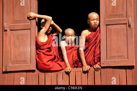 INLE-See, MYANMAR: Junge Mönche vom Kloster ovale Fenster in Shwe Yaunghwe Kloster in Nyaungshwe, Shan-Staat beobachten Stockfoto