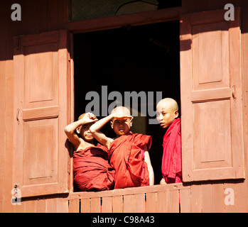 INLE-See, MYANMAR: Junge Mönche vom Kloster ovale Fenster in Shwe Yaunghwe Kloster in Nyaungshwe, Shan-Staat beobachten Stockfoto