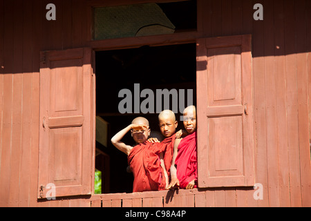 INLE-See, MYANMAR: Junge Mönche vom Kloster ovale Fenster in Shwe Yaunghwe Kloster in Nyaungshwe, Shan-Staat beobachten Stockfoto