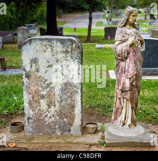 Verwitterter Grabstein mit leeren Exemplar neben Vintage Statue von Jesus Stockfoto