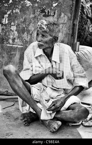 Alten indischen Mann sitzt auf der Straße. Andhra Pradesh, Indien. Monochrom Stockfoto