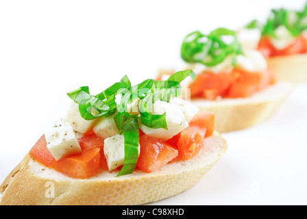 Bruschetta mit frischen gewürfelten Tomaten, Mozzarella und frischem Basilikum, isoliert auf weiss - flachen DOF Stockfoto