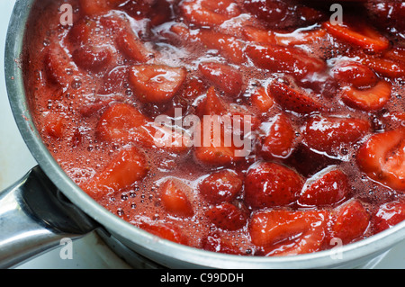 Nahaufnahme von Erdbeermarmelade wird in Edelstahl-Pfanne gekocht Stockfoto