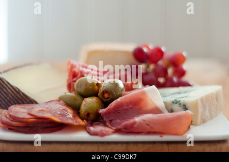 Kleine Antipasti-Platte mit überwiegend italienischen Käse und Fleisch mit Oliven und Trauben Stockfoto