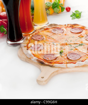 Italienisches original dünne Kruste Peperoni-Pizza mit Auswahl an Bieren und Gemüse auf Hintergrund Stockfoto