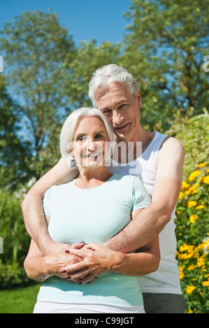Deutschland, Bayern, Mann und Frau umarmen einander im Garten, Lächeln, Porträt Stockfoto