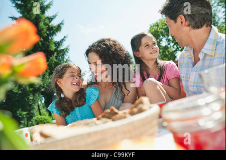 Deutschland, Bayern, Familie mit Kaffee und Kuchen im Garten, Lächeln Stockfoto