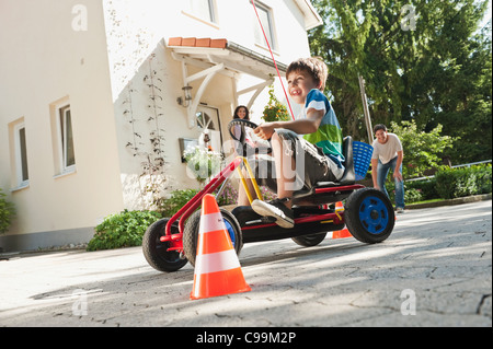 Deutschland, Bayern, junge fahren Pedal Go-Kart mit Eltern im Hintergrund Stockfoto