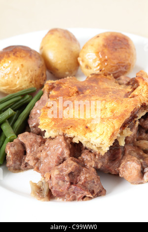 Eine traditionelle, hausgemachte Steak und Niere Torte mit Ofen gerösteten Kartoffeln und Gartenbohnen Bohnen serviert. Stockfoto