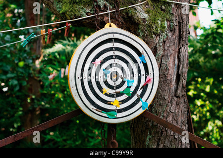 Deutschland, Hessen, Frankfurt, Dartscheibe mit Darts auf Baumstamm Stockfoto