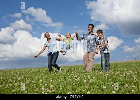 Deutschland, Bayern, Altenthann, Familie spielen zusammen in der Wiese Stockfoto