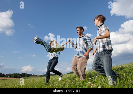 Deutschland, Bayern, Altenthann, Familie spielen zusammen in der Wiese Stockfoto