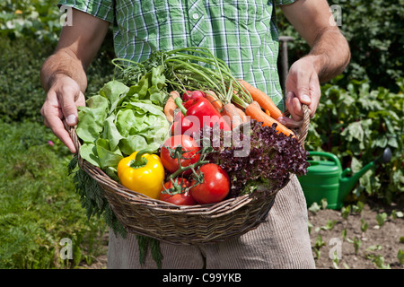 Deutschland, Bayern, Altenthann, Mann mit Korb voll mit Gemüse Stockfoto