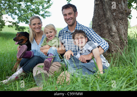 Deutschland, Bayern, Altenthann, Familie mit Hund unter Baum, Lächeln, Porträt Stockfoto