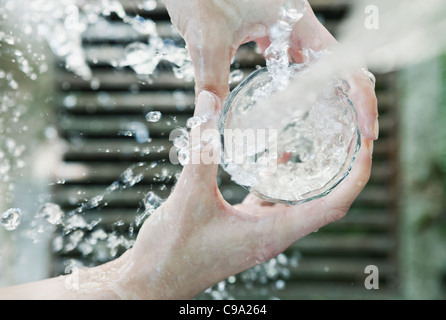 Italien, Toskana, Magliano, Nahaufnahme von Frau Hand Füllung Wasserglas Stockfoto