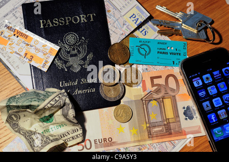 Paris-Stadtplan, amerikanischen Pass, Metro Tickets und Euro auf eine Tischplatte. Alle Besitztümer eines amerikanischen Reisenden in Frankreich. Stockfoto