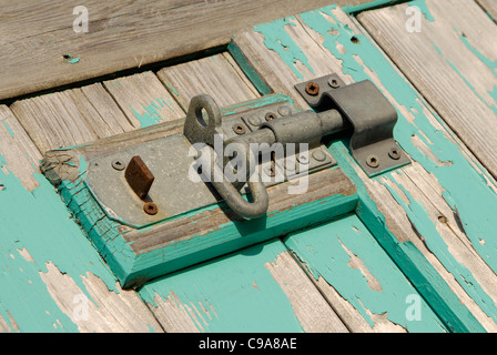 Riegel und Vorhängeschloss am Strand Hütte Tür. Holz und blauer Farbe verblasst Stockfoto