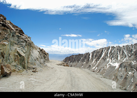 Eine Straße nach Leh mit Schnee verkleidet HimalajaGebirgszüge auf beiden Seiten aus dem Changla Pass oder Chang La Pass (El 5.360 m (17.590 Stockfoto