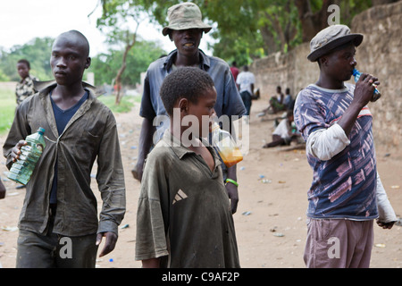 Mombasa, Kenia. Junge Männer hoch auf dem Leim. Die Straßengang Kinder und junge Männer sind offen Klebstoffschnüffeln und Spannungen hoch laufen. Stockfoto