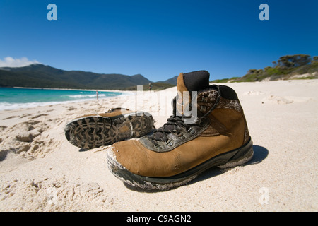 Wanderschuhe am weißen Sandstrand von Wineglass Bay.  Freycinet National Park, Tasmanien, Australien Stockfoto