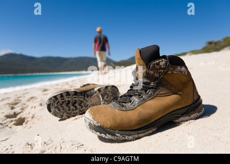 Wanderschuhe am weißen Sandstrand von Wineglass Bay.  Freycinet National Park, Tasmanien, Australien Stockfoto