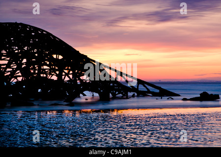 Sonnenuntergang hinter die Überreste der Brighton Pier West Stockfoto