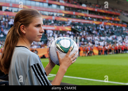 Ein Ballmädchen besitzt eine offizielle Spielball 2011 FIFA Frauen Welt Cup Gruppe A Spiel zwischen Frankreich und Deutschland. Stockfoto