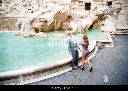 Frau Mann in den Trevi-Brunnen als Witz zu schieben Stockfoto