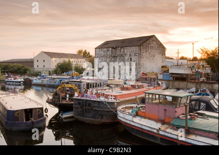 Boote (verfallene, REPARATURBEDÜRFTIG) am Fluß Calder Werft von alten heruntergekommenen Industrie Mühle günstig, Sonnenuntergang - Leeds, Yorkshire, England Stockfoto