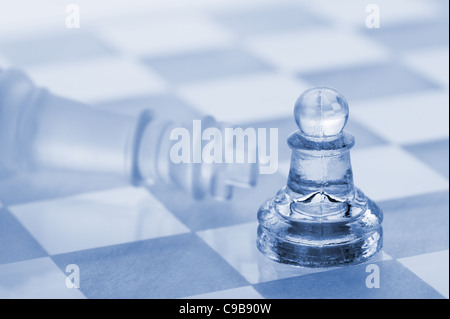 Glas-Schach. Ein Sieg der Bauer über ein König. Blau getönt. Stockfoto