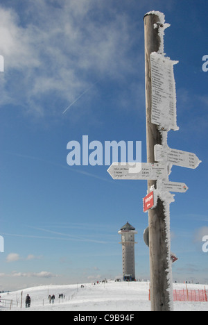 Verschneite Turm und Trail-Zeichen auf dem Feldberg-Gipfel, höchster Berg des Schwarzwalds in Baden-Württemberg, Deutschland Stockfoto