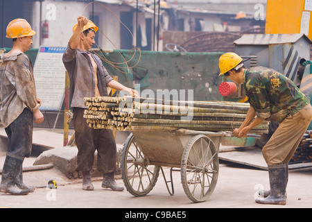 GUANGZHOU, Provinz GUANGDONG, CHINA - Bauarbeiter mit Wagen von Bambus in der Stadt Guangzhou. Stockfoto