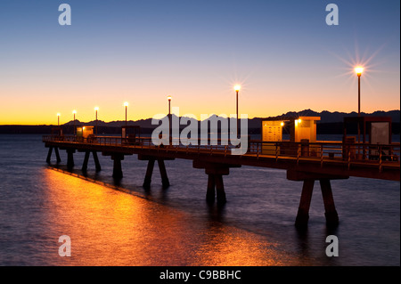 Silhouette Pier mit Menschen Angeln Dock bei Sonnenuntergang am Puget Sound mit Olympic Mountains Edmonds Washington State USA Stockfoto
