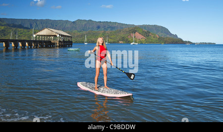 Paddleboarder in Hanalei Bay auf Kauai mit Hanalei Pier und den Mt. Makana genannt Bali Hai, im Hintergrund Stockfoto
