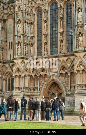 Gruppe von Touristen, die gerne an externe West Front der Wells Cathedral Stockfoto