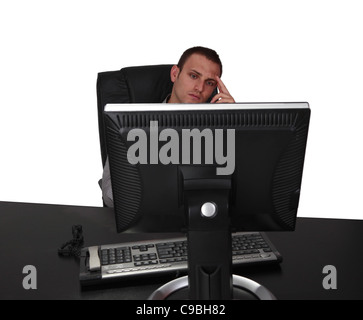 Bild eines jungen Geschäftsmann auf seinem Schreibtisch sitzen und denken, vor einem weißen Hintergrund isoliert. Stockfoto