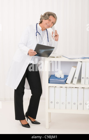 Professionelle Oberärztin Frau am Telefon halten Röntgen im Büro Stockfoto