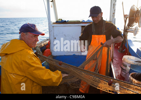 Fischer, die Kokons in Netzen auf Boot Stockfoto