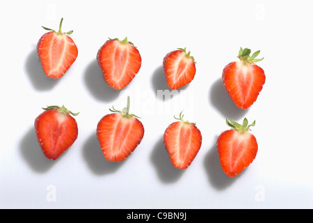 Die Hälfte geschnitten Erdbeeren auf weißem Hintergrund Stockfoto