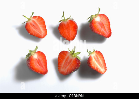 Die Hälfte geschnitten Erdbeeren auf weißem Hintergrund Stockfoto