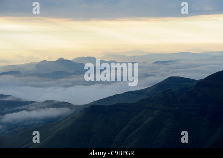 Tief liegende Wolken oben mit Spitze erhebt sich über in der Morgendämmerung, die Hexen, Amphitheater, Drakensberg Kwazulu-Natal, Südafrika Stockfoto