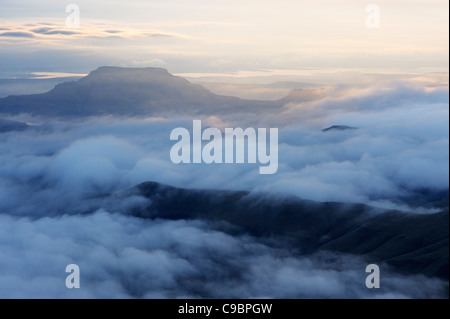 Tief liegende Wolken oben mit Spitze erhebt sich über in der Morgendämmerung, die Hexen, Amphitheater, Drakensberg Kwazulu-Natal, Südafrika Stockfoto