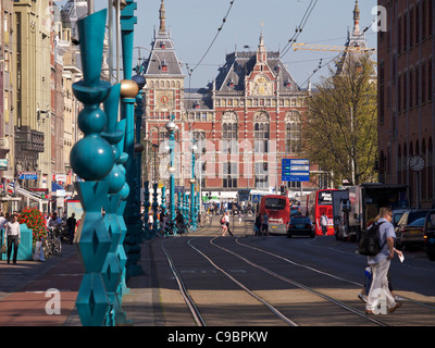 Amsterdam Hauptbahnhof mit der Straßenbahn, Busse und Menschen Damrak Straße zu überqueren. die Niederlande Stockfoto