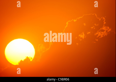 Tele-Blick auf die aufgehende Sonne hinter orange Wolken, Durban, Kwazulu-Natal, Südafrika Stockfoto