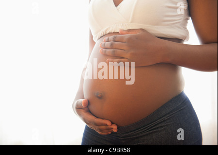 Vergrößerte Ansicht des Weibes Hände wiegend schwangeren Bauch, Johannesburg, Provinz Gauteng, Südafrika Stockfoto
