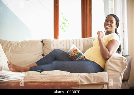 Schwangere Frau auf Couch sitzen, schreiben in Tagebuch, Johannesburg, Provinz Gauteng, Südafrika Stockfoto