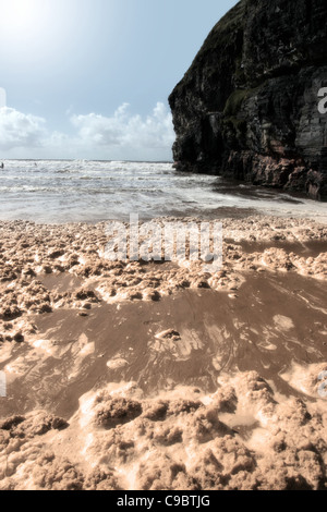 Sturmwellen an Ballybunion Strand Irland verlassen Schlamm und in seinem Gefolge Schaum Stockfoto